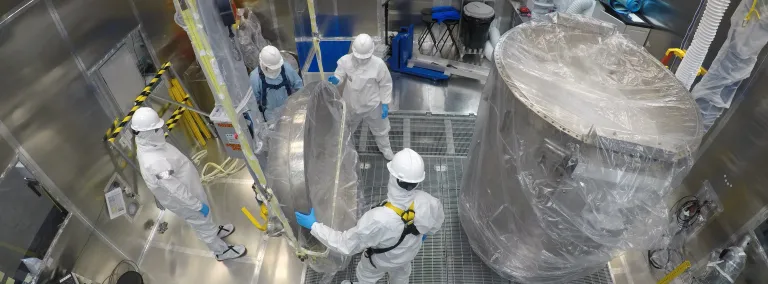 Engineers clean the LUX-ZEPLIN cryostat inside the Surface Lab's Class 1000 clean room in preparation for the next generation search for dark matter. 