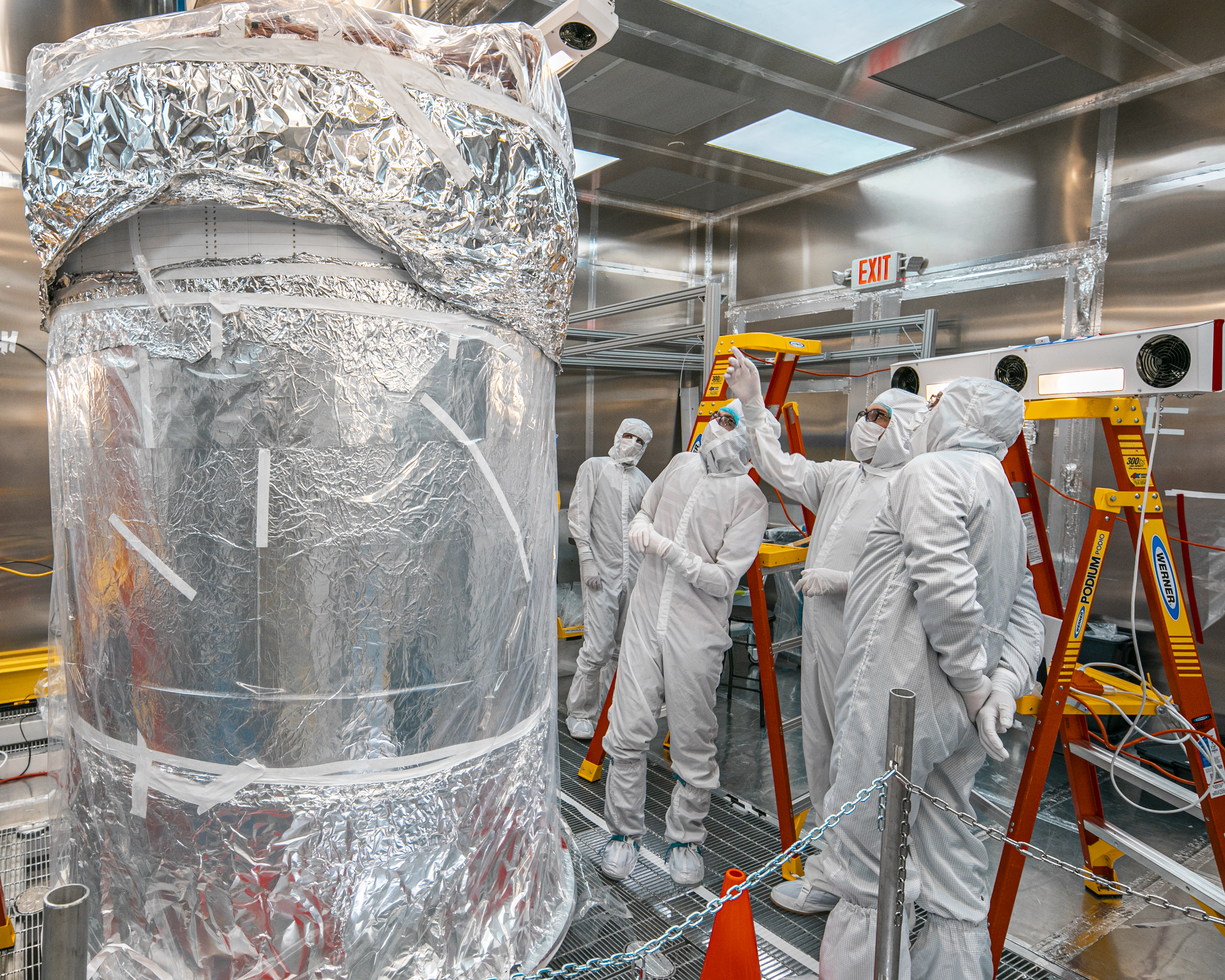 Researchers examine the foil-wrapped LUX-ZEPLIN xenon detector that was recently assembled in the Surface Assembly Lab cleanroom at Sanford Underground Research Facility on July 26, 2019. Photo by Matthew Kapust, Sanford Underground Research Facility.