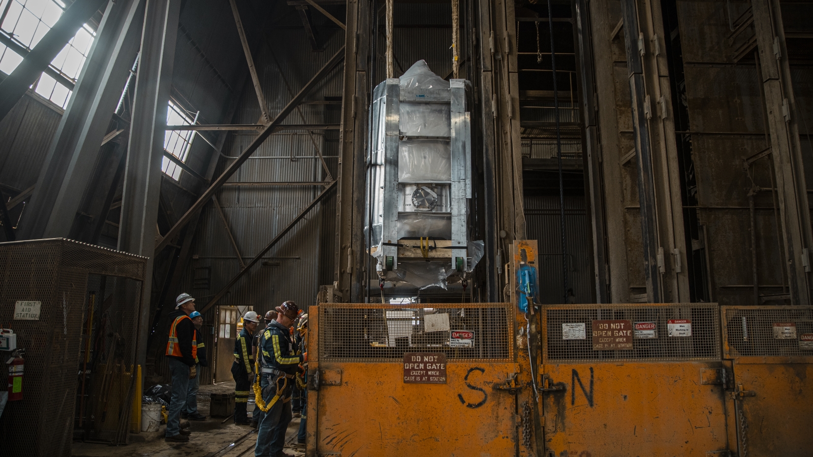 Engineers and infrastructure technicians at SURF lower a large piece of the LZ experiment down the Yates Shaft