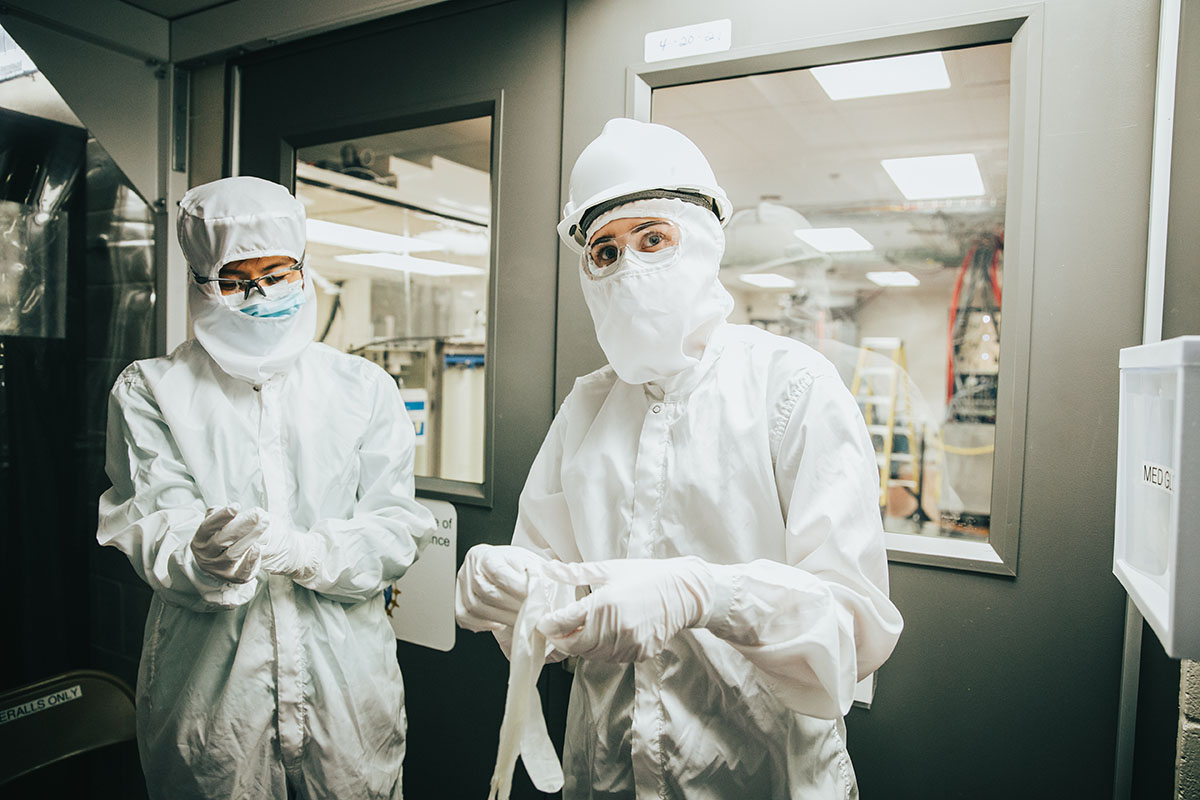 two people don cleanroom suits