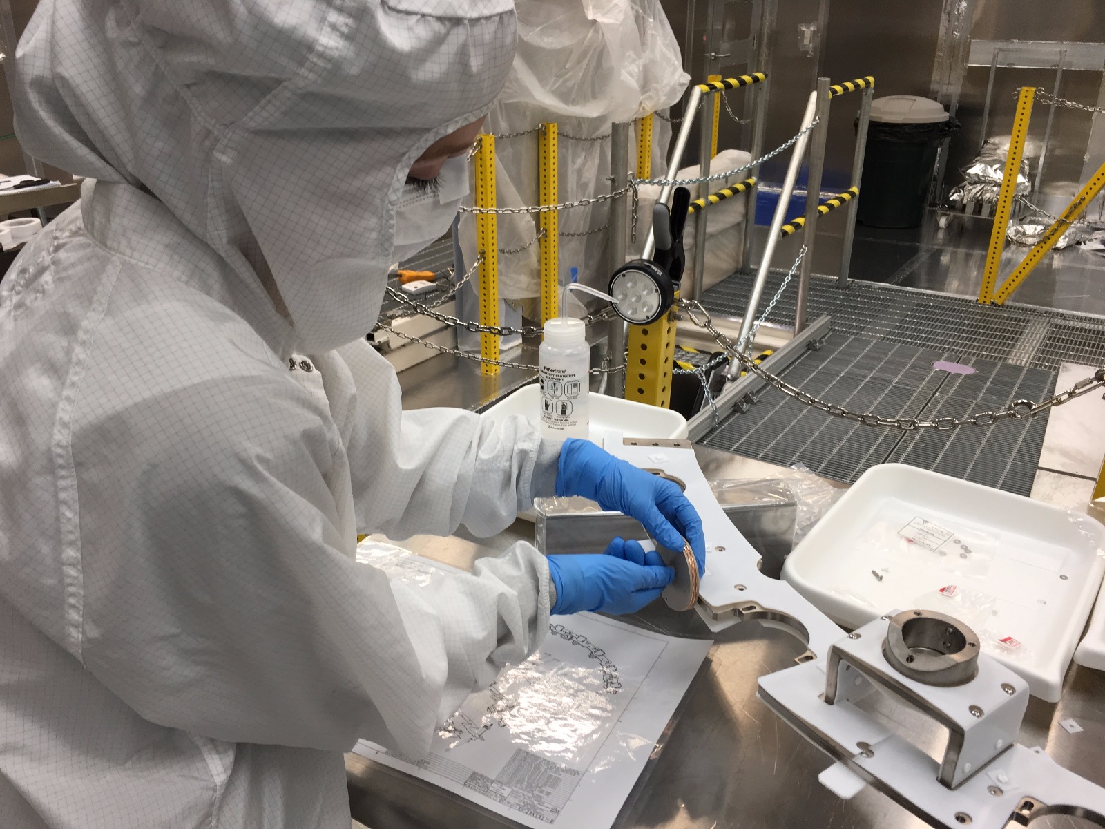 Researcher in clean suit installs a sensor