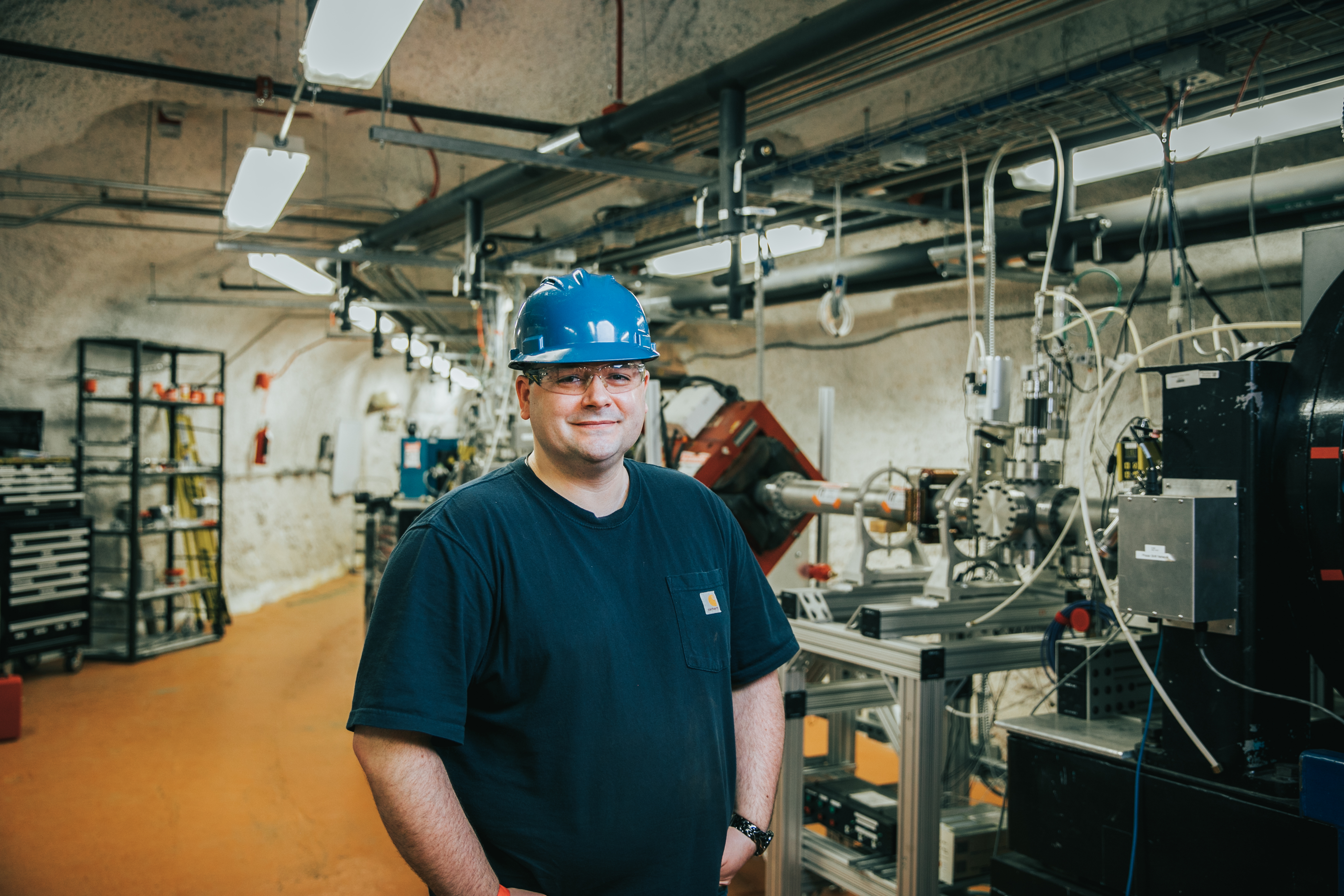 Researcher stands in front of accelerator in underground lab