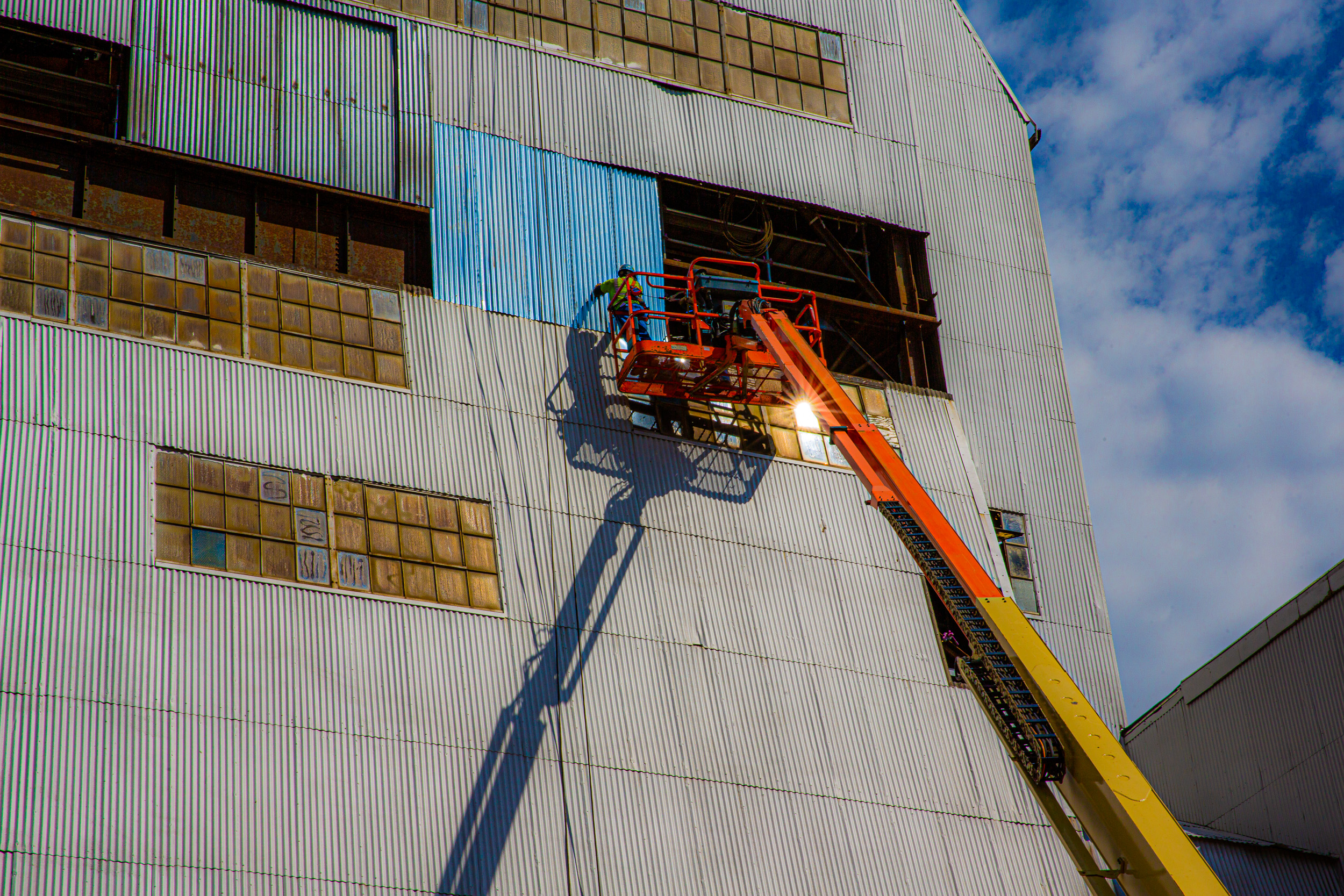 Crews do work on a headframe from an elevated platform