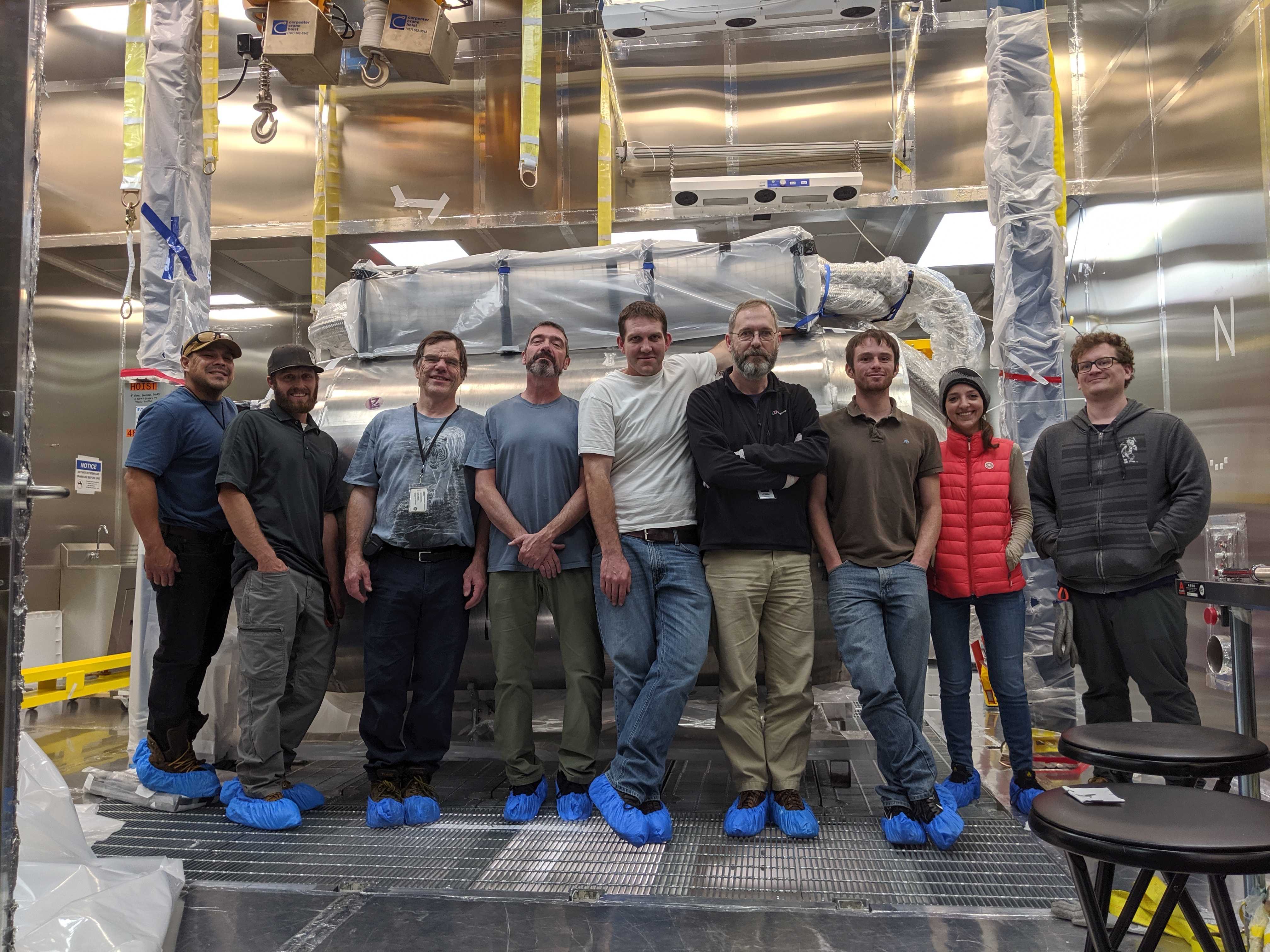 Nine people stand in front of the completed TPC detector
