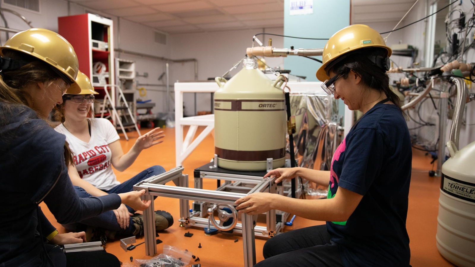 Students assembling supports on a detector.