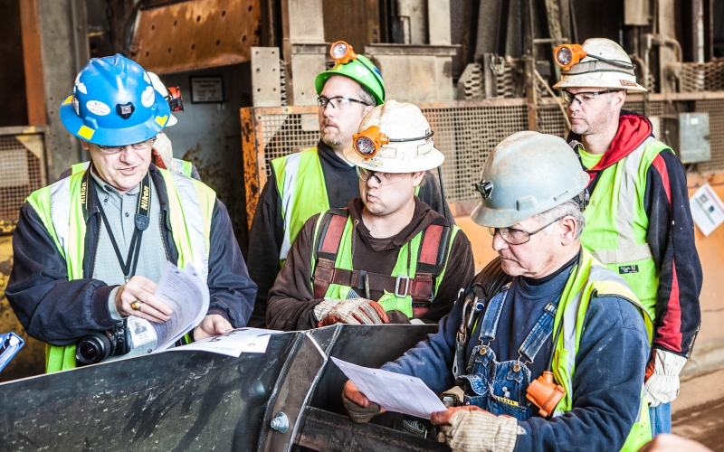 5 workers discussing a safety plan before their shift