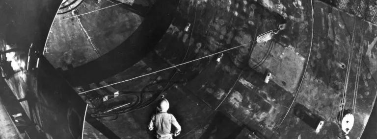 A man stands in a tank which is being built deep underground.