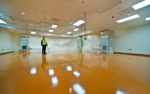 1 person stands in a shiny empty underground lab space.