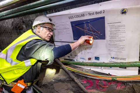 Bill Roggenthen points at a poster while speaking on a geothermal experiment at SURF.