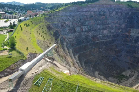 The last segment of the conveyor juts out into the Open Cut, a large pit in the earth.
